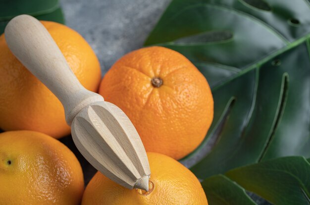 Naranjas y escariador de madera sobre mesa de mármol.