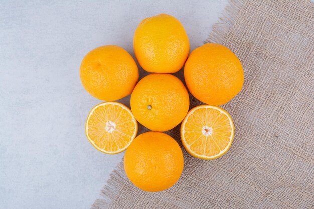 Naranjas frescas en cilicio en blanco.