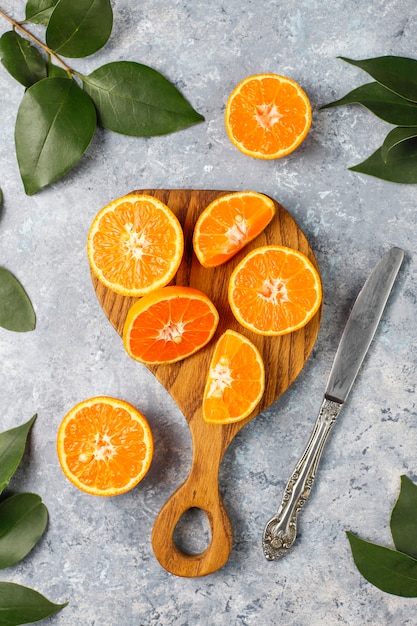 naranjas frescas en rodajas en la tabla de cortar sobre superficie de hormigón