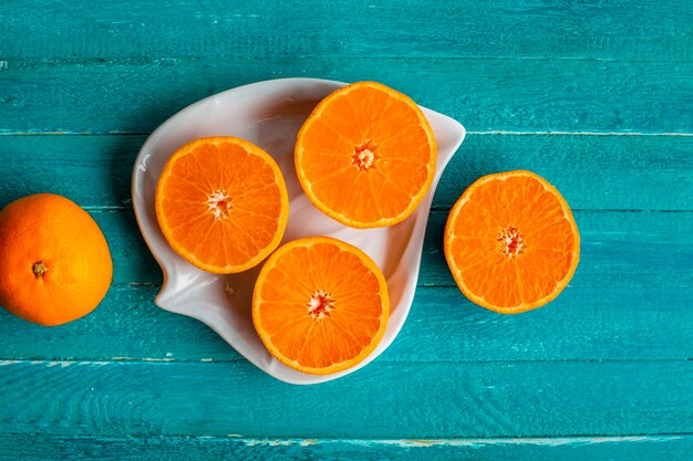 Naranjas naturales y frescas a medio cortar en plato