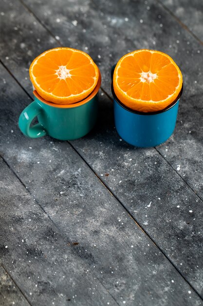 Naranjas picadas en tazas sobre una mesa de madera