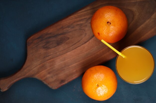 Naranjas con un vaso de jugo.