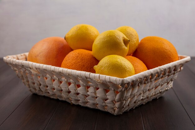 Naranjas de vista frontal en una canasta con limones y pomelos