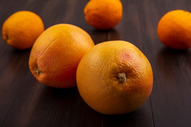 Naranjas de vista frontal sobre fondo de madera