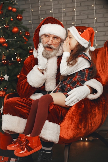 Navidad, niño y regalos. Santa Claus le trajo regalos al niño. Niña alegre abrazando a Santa.