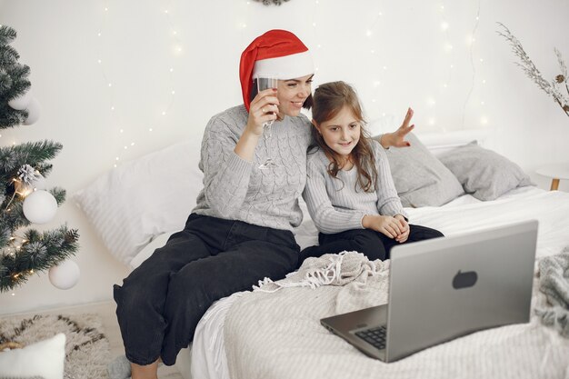 Navidad online. Celebración de Navidad año nuevo en cuarentena de coronavirus de encierro. Fiesta en línea. Madre con hija.