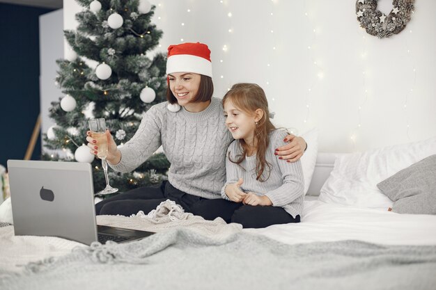 Navidad online. Celebración de Navidad año nuevo en cuarentena de coronavirus de encierro. Fiesta en línea. Madre con hija.