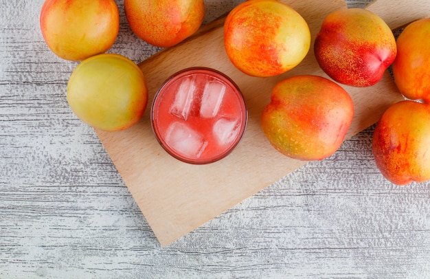 Foto gratuita nectarinas con jugo en la mesa de tabla grungy y corte, vista superior.