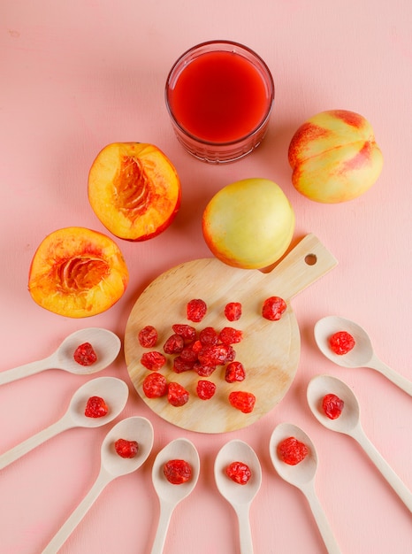 Nectarinas con jugo, vista superior de cereza seca en rosa y tabla de cortar