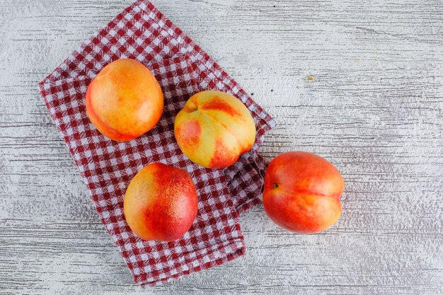 Nectarinas planas sobre toallas sucias y de cocina