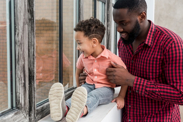 Foto gratuita negro, padre e hijo, mirar ventana