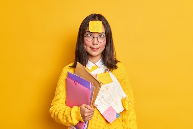 Nerd femenino inteligente divertido cruza los ojos tiene una pegatina con un gráfico dibujado en la frente