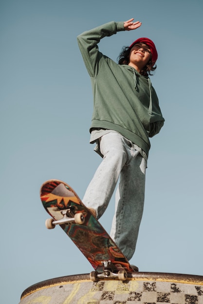 Ángulo bajo de adolescente en el skatepark divirtiéndose