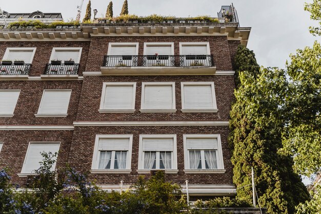 Ángulo bajo del edificio de apartamentos con ventanas en la ciudad