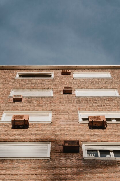 Ángulo bajo de edificio residencial en la ciudad con unidades de aire acondicionado