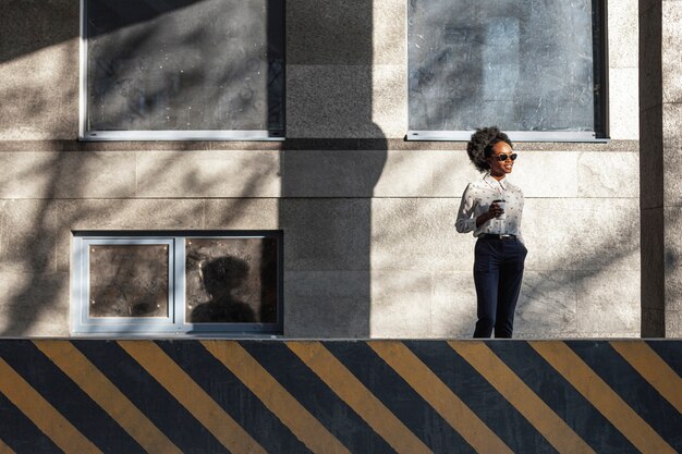 Ángulo bajo elegante mujer con café al aire libre