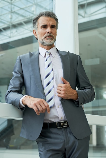 Ángulo bajo del empresario elegante de pie en el edificio de oficinas