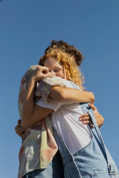 Ángulo bajo feliz pareja abrazándose