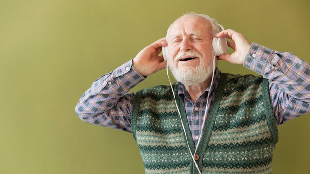 Ángulo bajo feliz senior disfrutando de la música