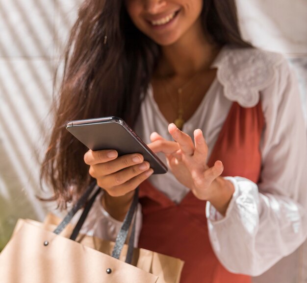 Ángulo bajo de hermosa mujer con smartphone