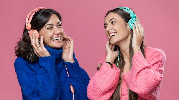 Ángulo bajo hija y madre escuchando música