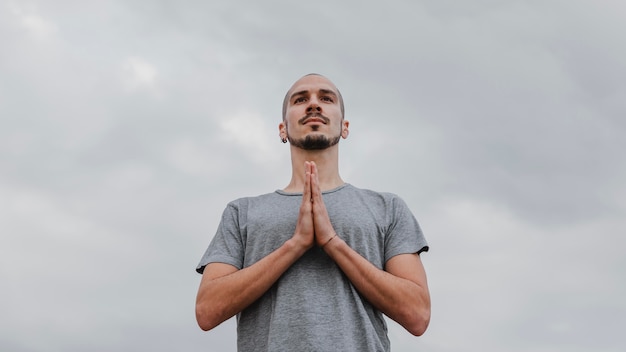 Ángulo bajo, de, hombre, aire libre, hacer, yoga