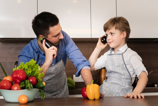 Ángulo bajo juguetón padre e hijo en la cocina