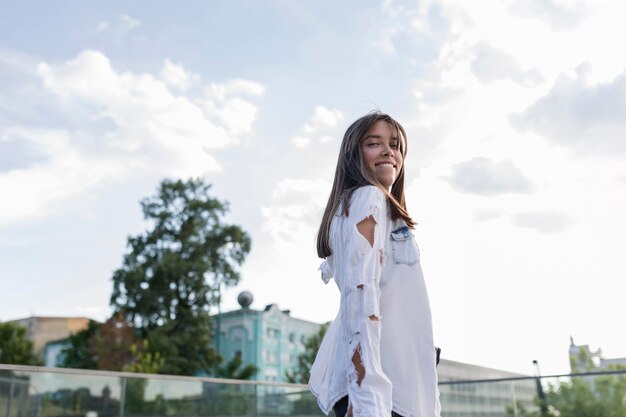 Ángulo bajo, mujer joven, sonriente