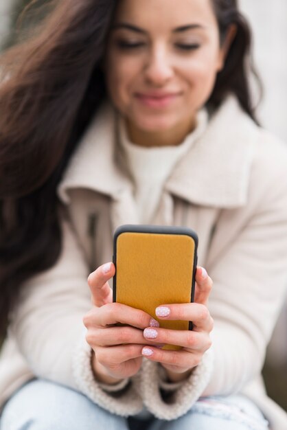 Ángulo bajo de mujer mirando smartphone