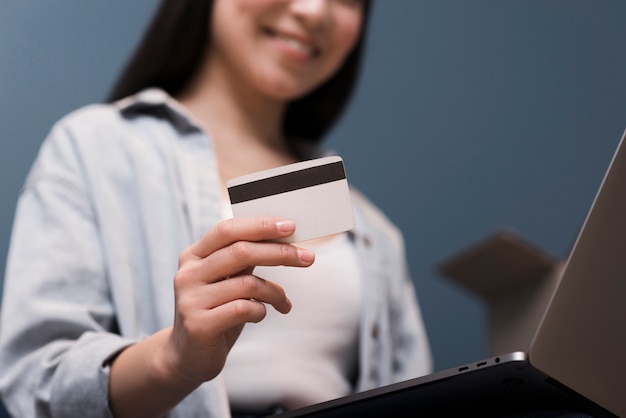 Ángulo bajo de mujer ordenando en línea con tarjeta de crédito