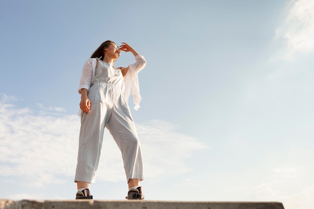 Ángulo bajo de mujer posando al aire libre con espacio de copia