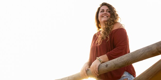 Ángulo bajo de mujer posando al aire libre