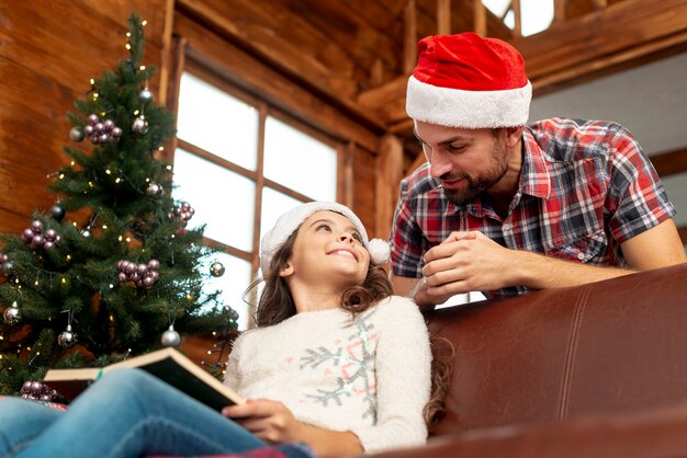 Ángulo bajo padre e hija con libro