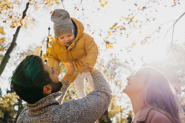 Ángulo bajo de padre y madre con bebé al aire libre