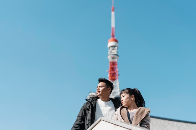 Ángulo bajo de pareja disfrutando de la vista de la ciudad con antena en la espalda