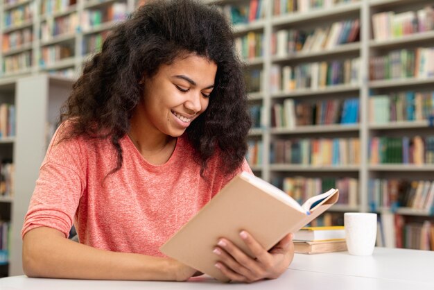 Ángulo bajo, sonriente, adolescente, lectura