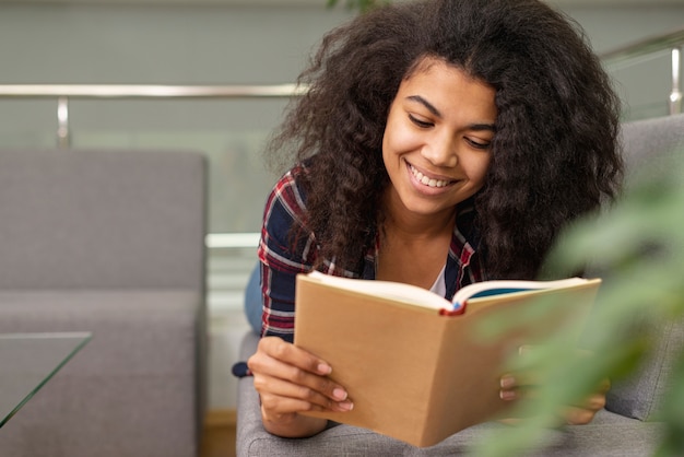 Ángulo bajo, sonriente, adolescente, lectura