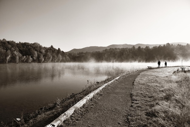 Niebla del lago en el parque con follaje otoñal y montañas con reflejo en Nueva Inglaterra Stowe