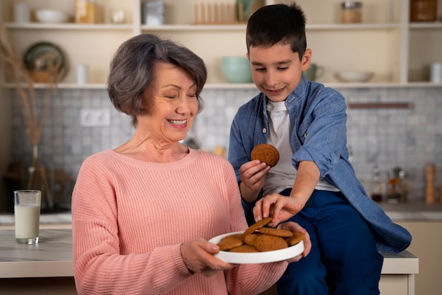 Foto gratuita nieto y abuela de tiro medio con galletas.