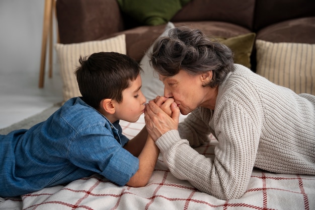 Foto gratuita nieto y abuela de tiro medio en el interior.