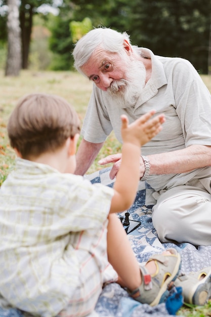 Foto gratuita nieto y abuelo jugando ajedrez