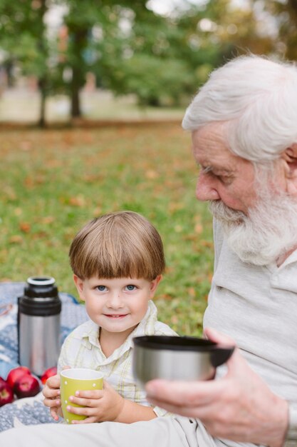 Nieto con el abuelo en el parque bebiendo té