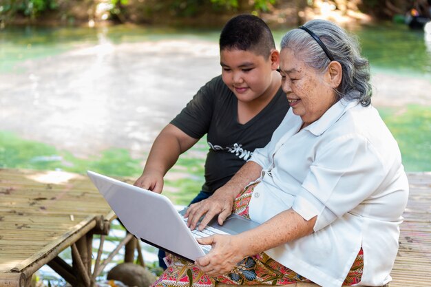 Nieto enseñando a su anciana a usar una computadora portátil
