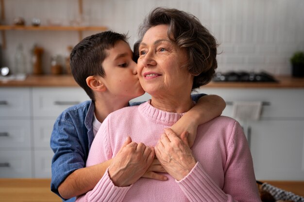 Nieto de tiro medio besando a abuela