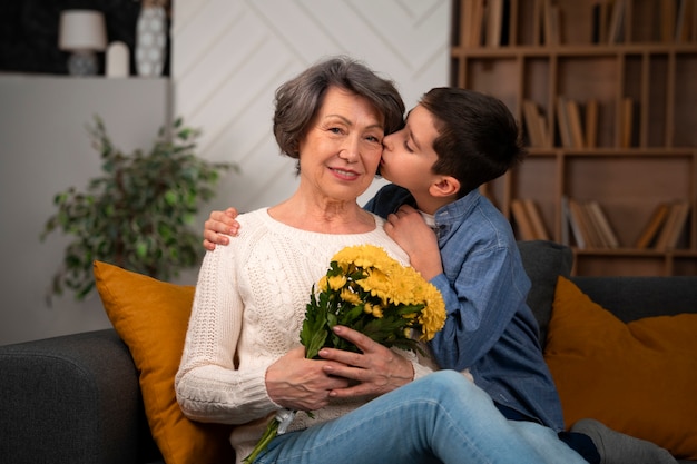 Nieto de tiro medio besando a abuela