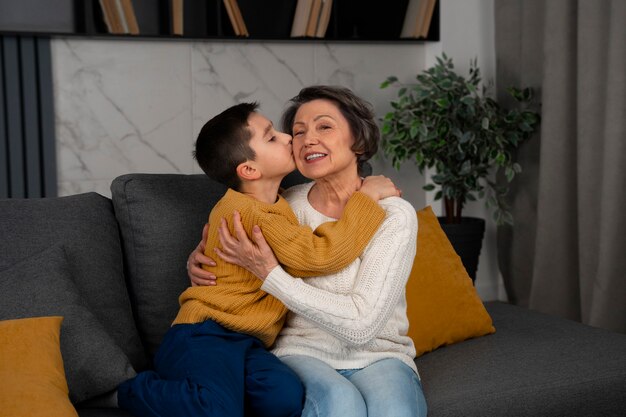 Nieto de tiro medio besando a abuela