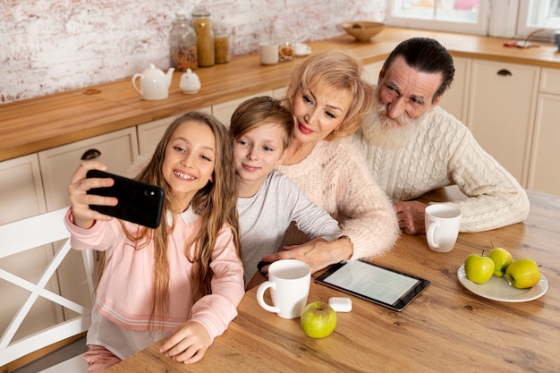 Foto gratuita nietos de alto ángulo tomando una selfie con sus abuelos