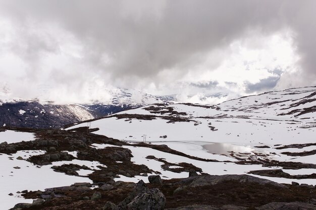 La nieve yace ante summints de roca azul en Noruega