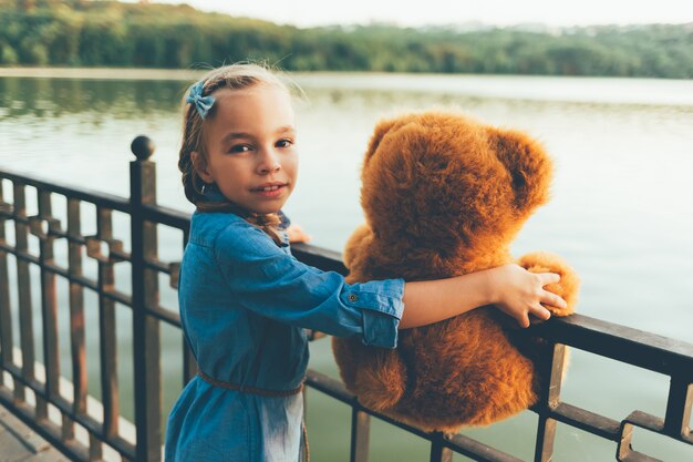 Niña abrazando un lindo oso de peluche