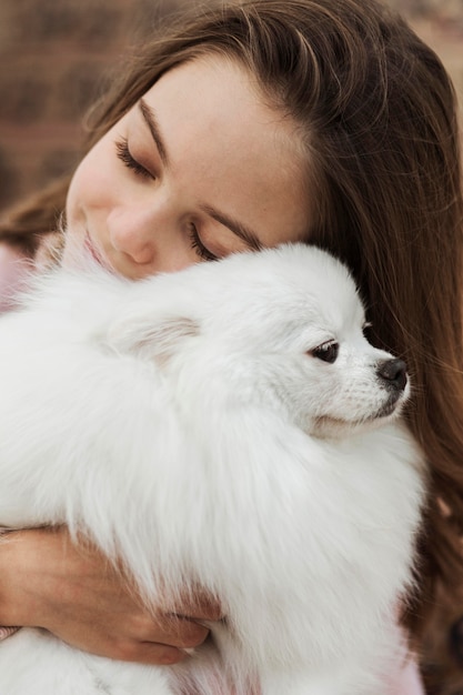 Niña abrazando a su cachorro esponjoso